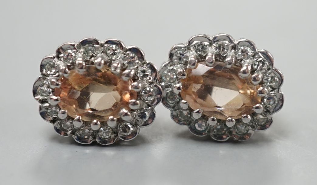 A pair of modern 9ct gold, topaz and diamond set oval cluster earrings, 11mm, gross weight 2.8 grams.